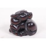 A carved hardwood netsuke in the form of a water buffalo, signed, 1½" wide