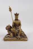 A Chinese filled metal Buddha seated on a temple lion, 4 character mark to base, 8½" high