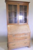 A late Victorian oak fall front bureau bookcase, with glazed upper section, fitted fall and three