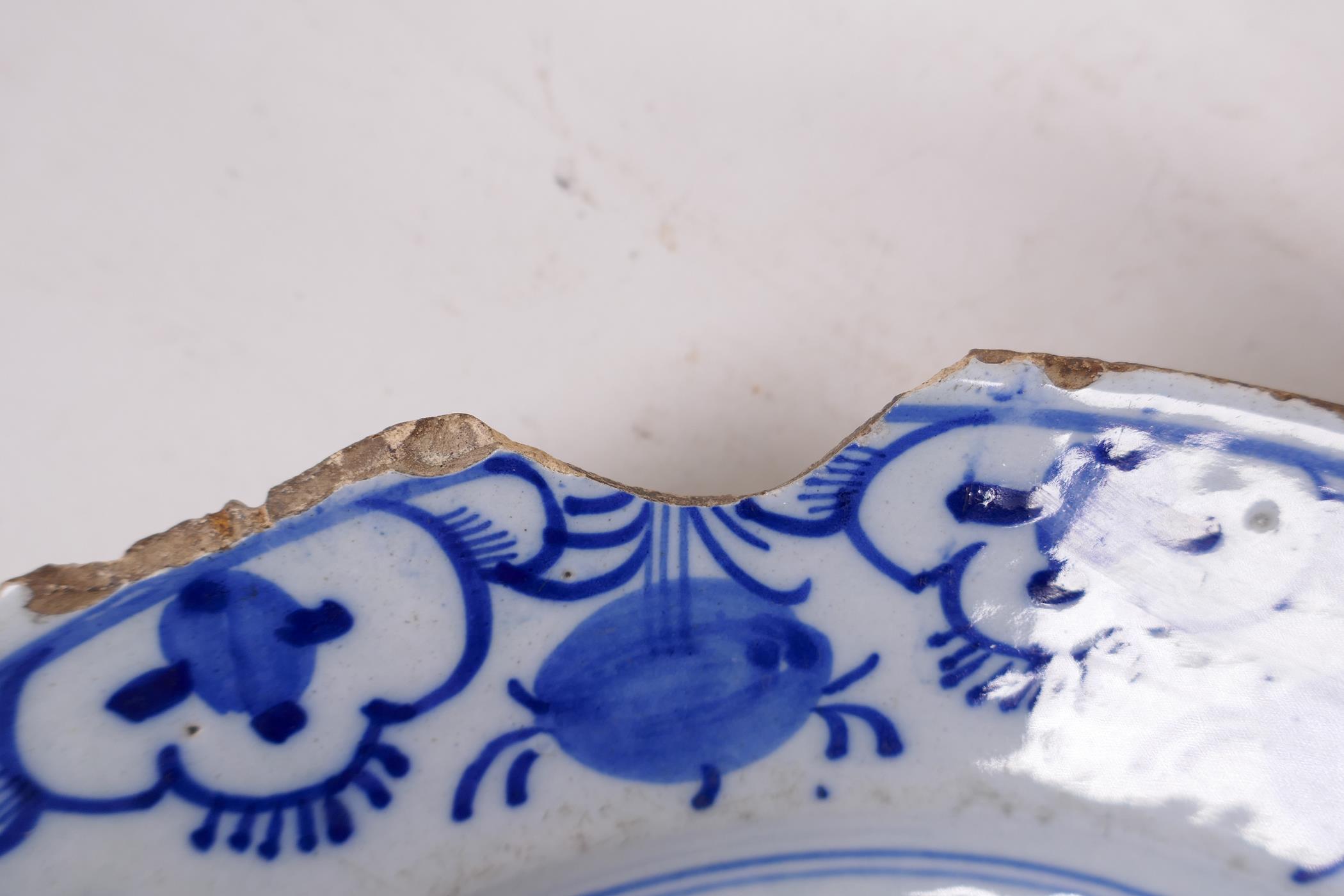 An antique Delft tin glazed blue and white charger painted with flowers and fruit, chip to rim, 13½" - Image 5 of 5