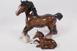A Beswick figurine of a shire horse, 8" high, and another of a foal lying down, number 915