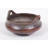 A small Chinese bronze censer with phoenix eye handles and three cast supports, impressed seal