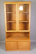 A mid C20th bookshelf with glazed doors to the upper section and a cupboard to the lower section,