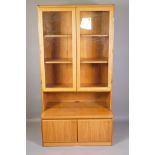 A mid C20th bookshelf with glazed doors to the upper section and a cupboard to the lower section,