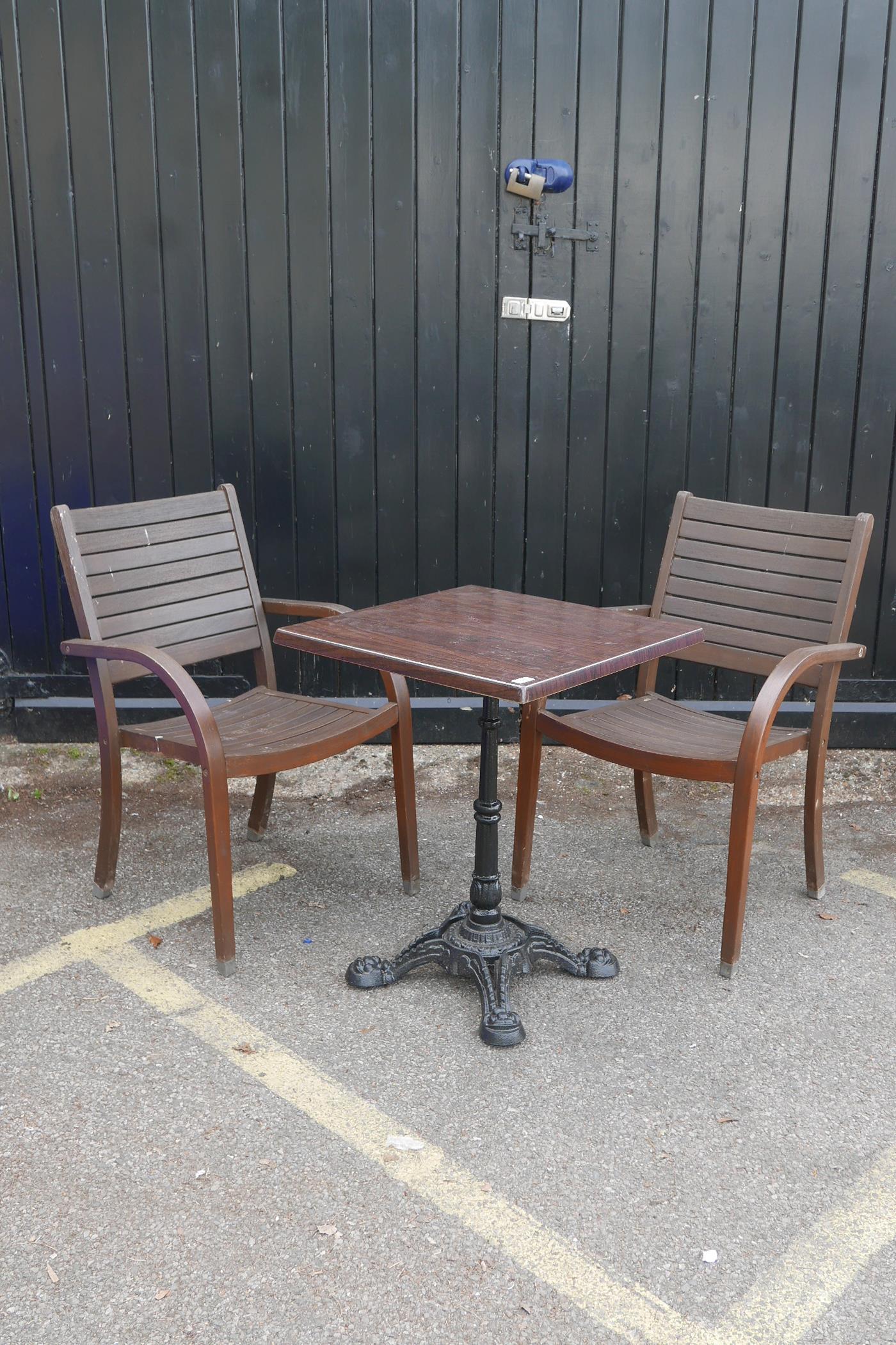 Two teak garden elbow chairs and a wrought iron and plastic bistro table, 23" x 23", 29" high