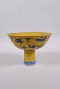 A Chinese Ming style yellow ground porcelain stem bowl with blue and white decoration of cranes in