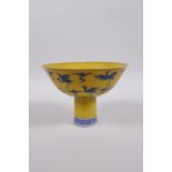 A Chinese Ming style yellow ground porcelain stem bowl with blue and white decoration of cranes in