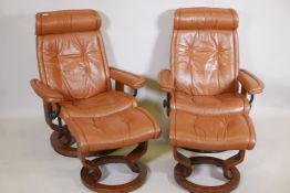 A pair of leather upholstered stressless tilt recliner chairs with matching stools