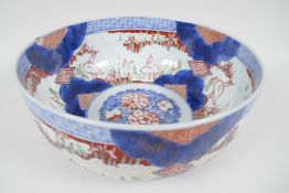A C19th Japanese Imari porcelain bowl painted with herons amongst the reeds, in traditional colours,
