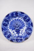 A large antique Delft blue and white charger painted with feathers, 13½" diameter