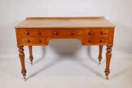 A Victorian five drawer faded mahogany kneehole desk, raised on turned supports, 48" x 21" x 30"