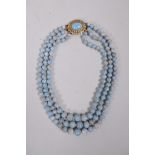 A graduated turquoise three strand necklace with a gilt metal clasp, 15½" long