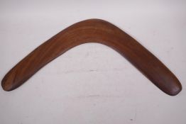 An Australian aboriginal carved wood boomerang, Queensland label verso, 20" wide