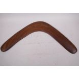 An Australian aboriginal carved wood boomerang, Queensland label verso, 20" wide