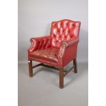 A red leather button back club chair, 35" high