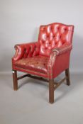 A red leather button back club chair, 35" high