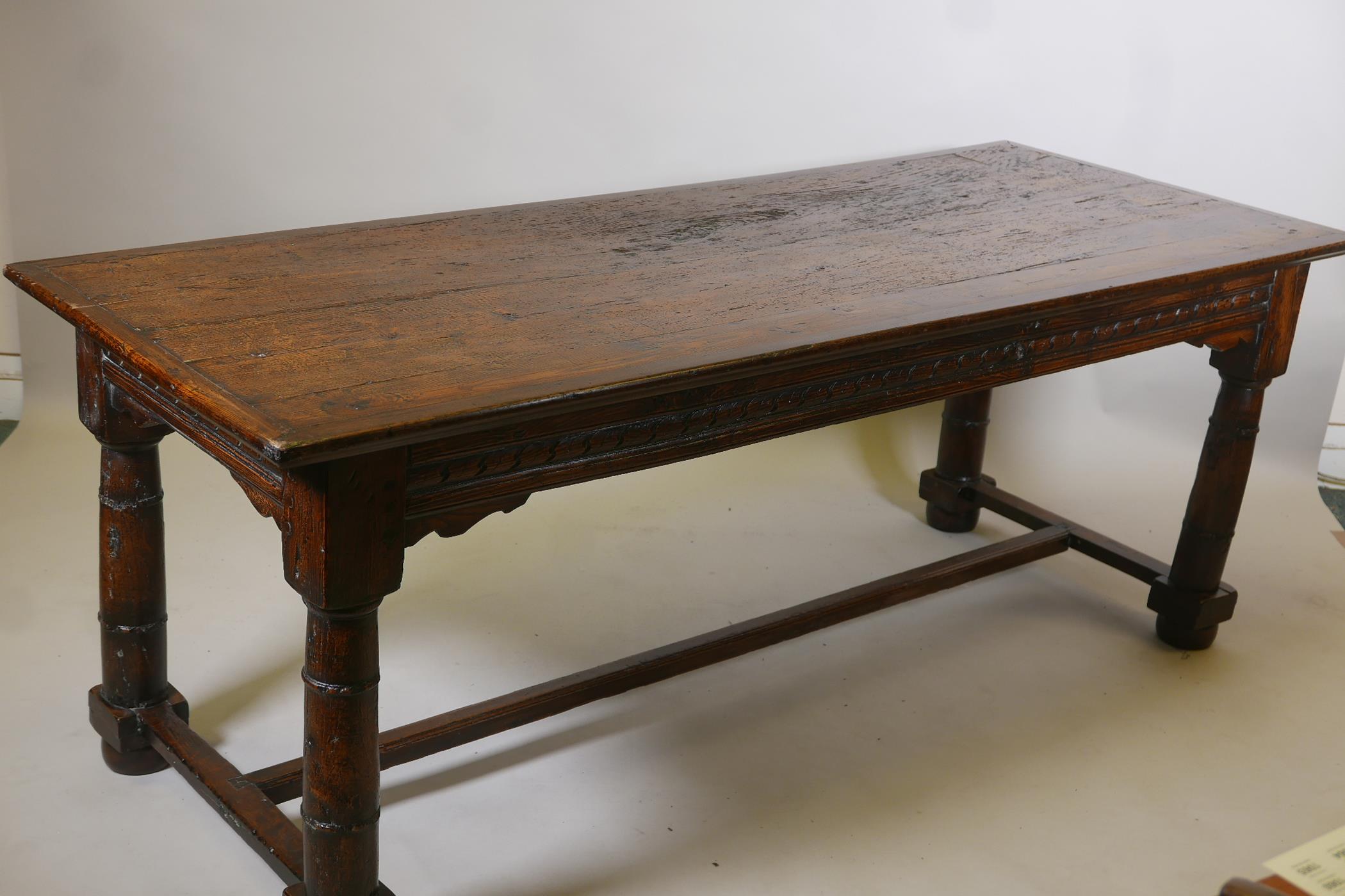 An antique oak refectory table, with plank top and carved frieze raised on gun barrel turned - Image 4 of 9