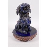 A blue glazed Chinese pottery figure of a kylin seated on a lotus shaped mount, A/F, 9" high