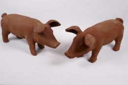 A pair of cast iron garden figures of pigs, 17" long