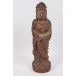 A Chinese carved wooden figure of Quan Yin, with traces of original paint, 11½" high