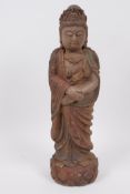 A Chinese carved wooden figure of Quan Yin, with traces of original paint, 11½" high