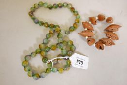 A string of coloured hardstone beads, 31" long, and a carved nut bangle