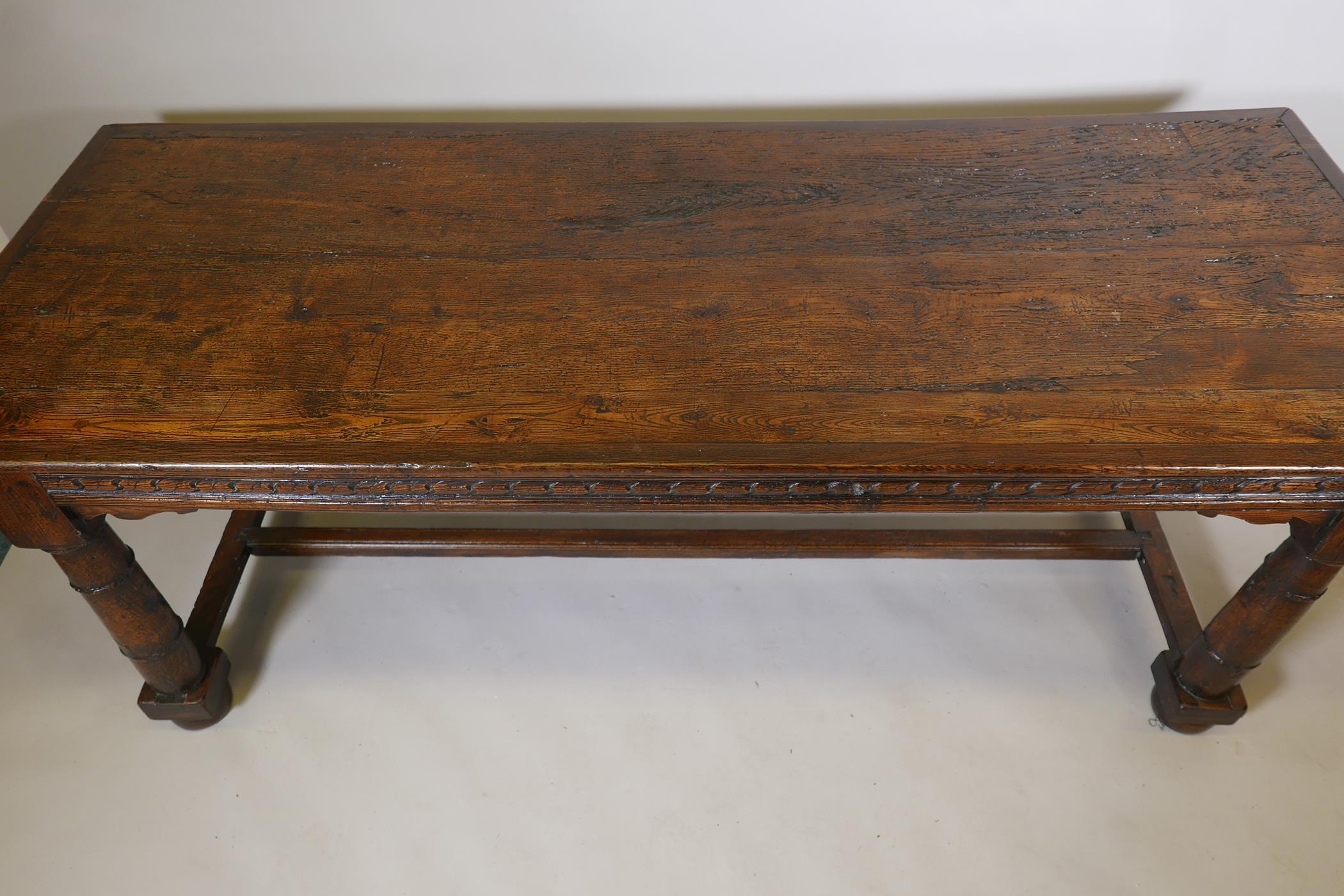 An antique oak refectory table, with plank top and carved frieze raised on gun barrel turned - Image 2 of 9