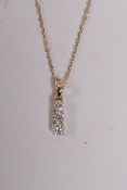 An 18ct yellow gold and three stone diamond drop pendant necklace, 26 points