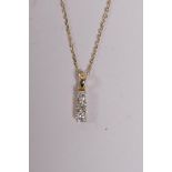 An 18ct yellow gold and three stone diamond drop pendant necklace, 26 points