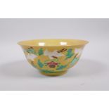 A Chinese yellow ground porcelain rice bowl decorated with red crowned cranes in flight, 6 character