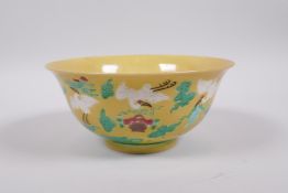 A Chinese yellow ground porcelain rice bowl decorated with red crowned cranes in flight, 6 character