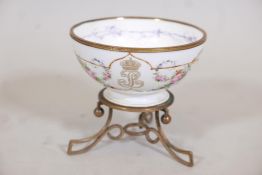 A Sevres bowl, hand painted with swags of roses and gilt highlights, raised on an ormolu base,