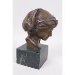 A bronze bust after the antique, mounted on a marbled socle, 5" high