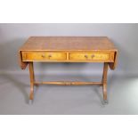 A Regency style yew wood veneered sofa table with two drawers, raised on pierced shaped ends with