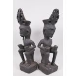 A pair of Indonesian tribal carved wood seated figures, 13" high