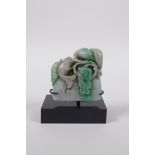 A Chinese mottled green jade carved ornament decorated with goldfish and lotus flowers on a