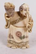 A carved and inked bone netsuke carved as a man with basket and pipe, signed, 2" high