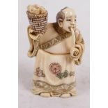 A carved and inked bone netsuke carved as a man with basket and pipe, signed, 2" high