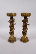 A pair of Chinese bronze pricket candlesticks, with coiled dragons around the stems, 4 character