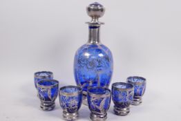 A silver overlaid blue glass liqueur set of eight decanters and six glasses decorated with leaves