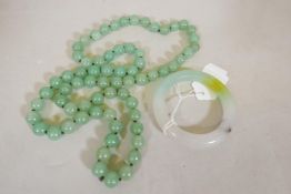 A jade bangle, 2¼" internal diameter, and a string of jade beads, 31" long