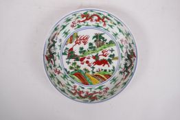 A Ming style wucai porcelain dish with dragon and kylin decoration, 6 character mark to base,