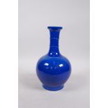 A Ming style blue glazed porcelain bottle vase with a ribbed neck and incised dragon decoration, 6