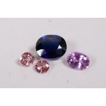 A large synthetic sapphire and two rose coloured synthetic sapphires, and another, largest 3/4"