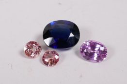 A large synthetic sapphire and two rose coloured synthetic sapphires, and another, largest 3/4"
