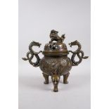 A Bronze Chinese dragon censer and cover with two handles and a fo dog knop, raised on tripod