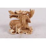 A bone netsuke carved as a dragon, signed, 1½" high