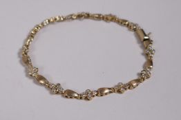 A 10ct yellow gold and diamond set bracelet, 7" long