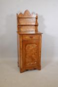 A C19th Continental elm cabinet, inset with pollard veneers, the Gothic style back with open shelves
