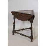 A C19th oak cricket corner table with three drop flaps, raised on turned supports united by